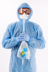 portrait of a man in a chemical protection suit, medical gloves, a mask and glasses holds a package with the planet Earth inside on a white background
