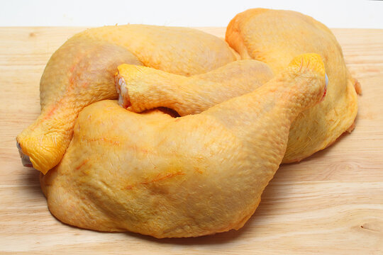 muslos de pollo sobre tabla de cocina