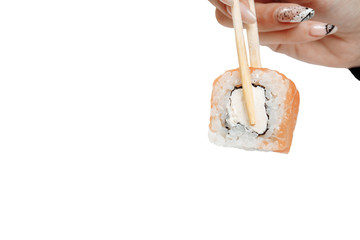 Roll Philadelphia with salmon, avocado cream cheese and cucumber. Japanese sushi with chopsticks. A Hand is holding the roll with sticks on white background