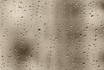 Autumn day. Window of a residential building in an apartment. Horizontal frame. Rain drops on the windows. Soft focus. Black and white image, soft contrast, sepia.