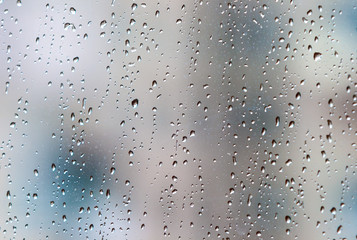 Autumn day. Window of a residential building in an apartment. Horizontal frame. Rain drops on the windows. Soft focus.