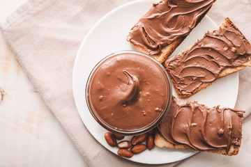 Plate with fresh bread and chocolate paste on table