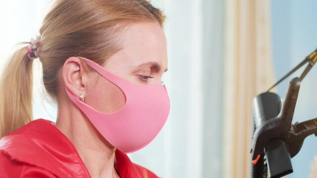 Groomer blows a hair dryer and combes the white dog. Slow motion. Blue background. Animal Bichon.