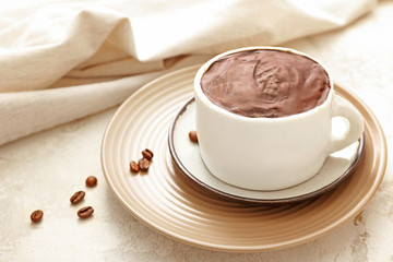 Chocolate cake in shape of coffee cup on light background