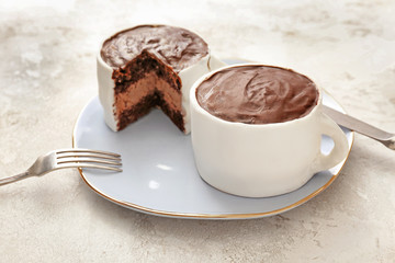 Chocolate cakes in shape of coffee cups on color background