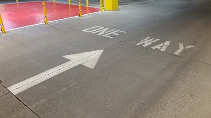 One way sign on the driveway in parking garage