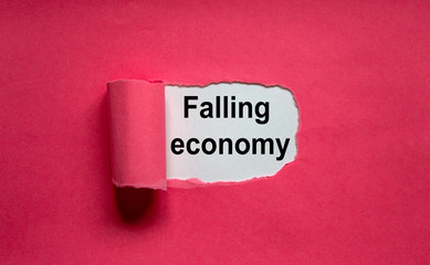 The text 'falling economy' appearing behind torn pink paper.