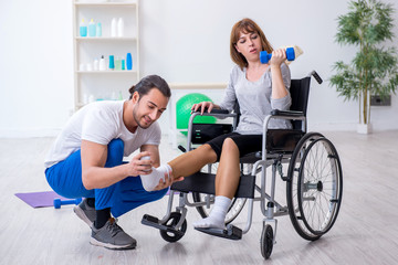 Woman in wheel-chair doing sport exercises with personal coach