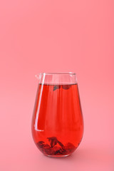 Jug of tasty cold ice tea on color background