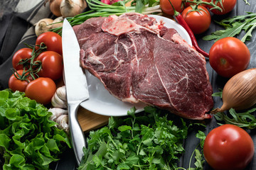 a piece of fresh choice beef lies on a wooden chopping Board. Fresh meat and vegetables Juicy steak with greens. Proper, balanced nutrition.