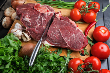 a piece of fresh choice beef lies on a wooden chopping Board. Fresh meat and vegetables Juicy steak with greens. Proper, balanced nutrition.