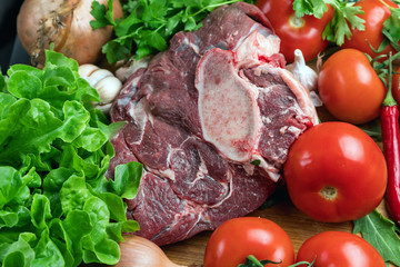 a piece of fresh choice beef lies on a wooden chopping Board. Fresh meat and vegetables Juicy steak with greens. Proper, balanced nutrition.