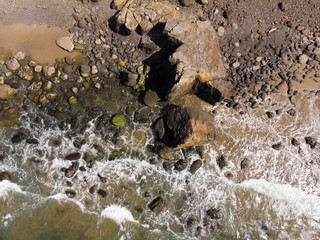 Ocean and rocky stone beach. Top view, texture and landscape.