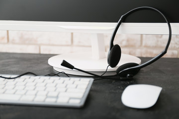 Headset and computer on table of technical support agent in office