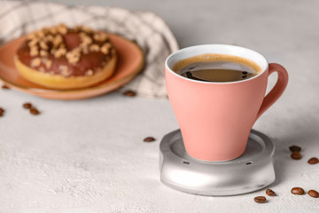 Cup of coffee with heater on table