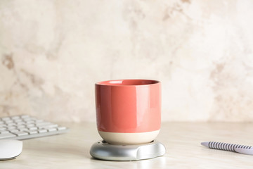 Cup of coffee with heater on table