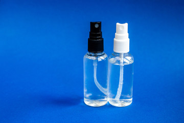 Hand picked two sanitizer spray to use as protection against coronavirus onblue background