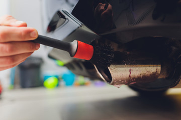 Car exhaust pipe with soap. Car wash background. brushing