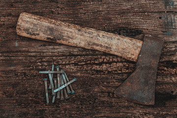 Axe and nails over a wooden table.