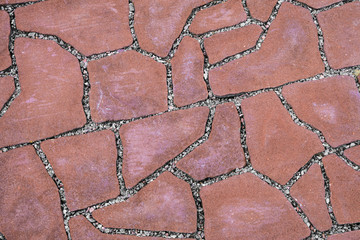 Red pavement covering. Footpath paved with tiled stone.