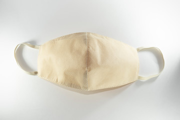 Beige reusable medical mask on a white background