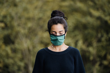 photo of a young woman in the forest wearing a face mask