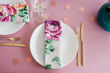 Guest place, table setting in dusty pink colors with beautiful white dishes, golden cutlery,...