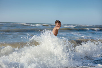 Fototapeta premium a child jumps in the waves