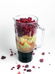 Smoothie Mixer mit verschiedenem Obst und Saft, Bunter Mixer mit Melone, Himbeeren, Johannisbeeren und Apfelsaft