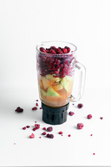 Smoothie Mixer mit verschiedenem Obst und Saft, Bunter Mixer mit Melone, Himbeeren, Johannisbeeren und Apfelsaft