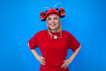portrait of a young female fan in red uniform on a blue background, a cheerful cheerleader is smiling