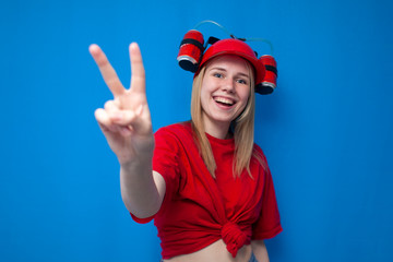 girl fan shows fingers number two on a blue background and smiles, cheerleader in uniform