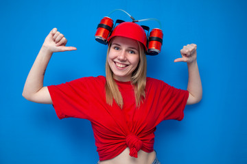 portrait of a young female fan in red uniform on a blue background, a cheerful cheerleader is smiling