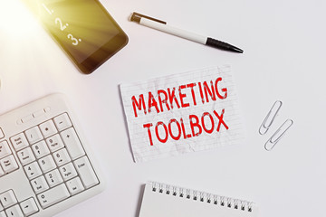 Writing note showing Marketing Toolbox. Business concept for Means in promoting a product or services Automation Flat lay above computer mobile phone pencil and copy space note paper