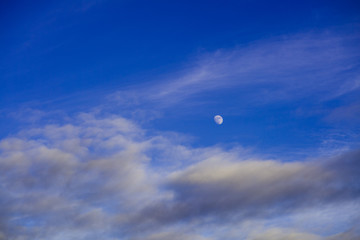 Beautiful waxing gibbous moon and beautiful blue sky and some scattered clouds