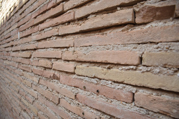 Naklejka premium Pared de ladrillo rústico y tonos marrones, cuyas lineas convergen fuera de plano.