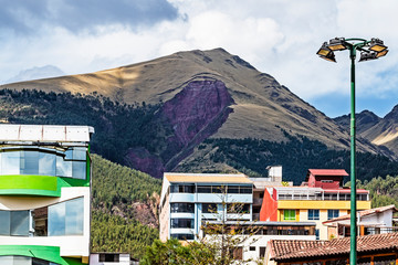 Cusco city modern colorful building on Larapa park with big Pillku Urku mountain behind