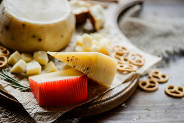 Assorted cheeses with pretzels on the cutting Board. On a wooden background,elective focus
