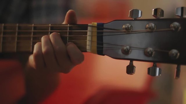 Girl playing the guitar. Fingers plucked strings on the guitar fretboard
