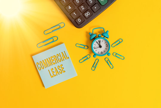 Text sign showing Commercial Lease. Business photo text refers to buildings or land intended to generate a profit Metal retro alarm clock wakeup clips calculator notepad colored background