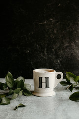 cup of coffee with leaves dark background