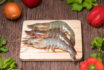 Fresh shrimps or prawns raw on wooden board , Fresh white shrimps in wooden background.
