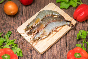 Raw White shrimps on the wood plate with ingredients, Fresh raw White prawns on  wood plate  over wooden table