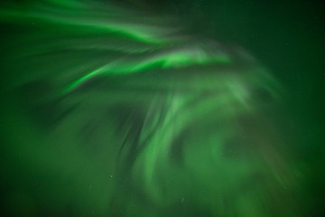 Astonishing, amazing northern lights aurora borealis seen in Yukon Territory, northern Canada in fall autumn. Looking directly up into the sky with green view & stars. 