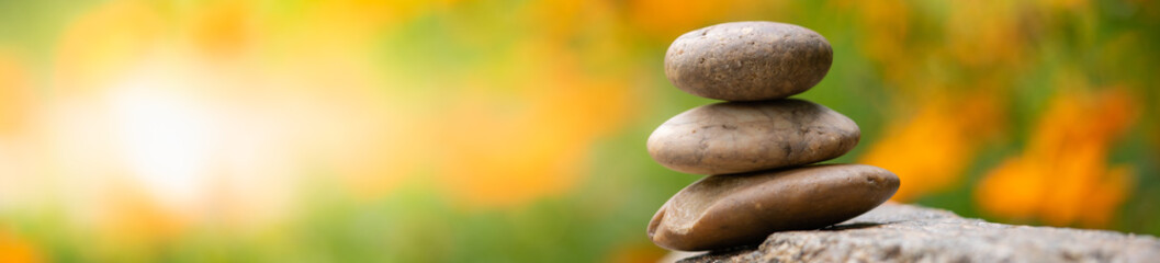 Stack of stones pyramid on blurred green yellow in garden using as background  natural nature spa cover page concept.
