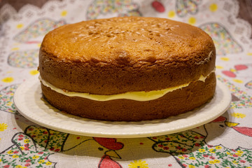 Torta de vainilla con crema sobre mantel floreado