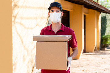 Delivery man delivering goods with gloves and mask at home. Delivery concept.