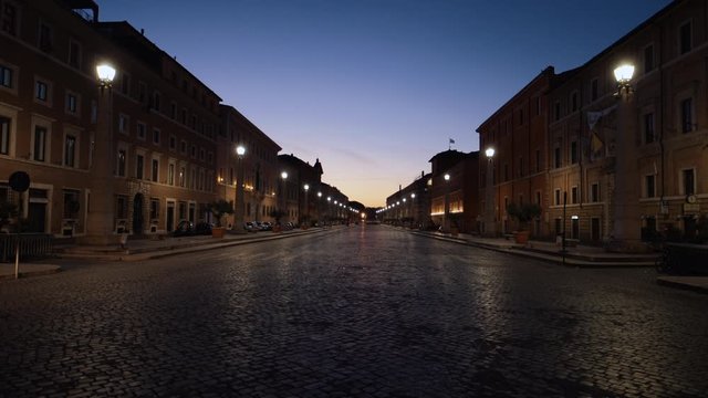 Dolly shot on the Via della Conciliazione street, away from the Piazza San Pietro, during sunrise, in Rome, Italy