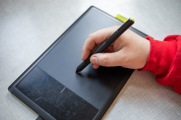 Graphic table and pen in hand of artist