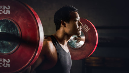 asian strong athletic man having workout and bodybuilding with barbells weight lifting backsquat...